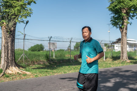 A man is jogging along a scenic path, which is beautifully surrounded by lush greenery and trees