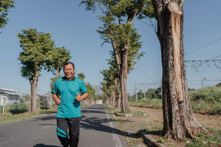 A cheerful and lively man jogs energetically along a sunny, beautiful pathway surrounded by trees