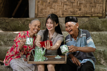 A loving family shares tea and laughter in a warm, traditional setting, creating memoriesの写真素材