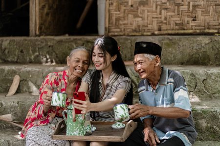 A joyful moment shared by elders and a young woman in a natural, rustic settingの写真素材