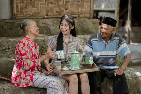 Three people gather to enjoy tea, sharing laughter and experiencing joy togetherの写真素材