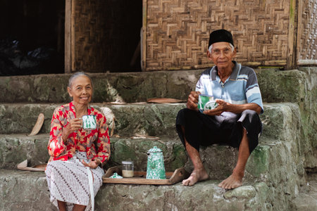 An elderly couple enjoys a delightful cup of tea together in a beautiful traditional settingの写真素材