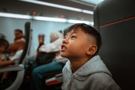 A young boy gazes upwards, deeply captivated and fascinated during a flight journeyの写真素材