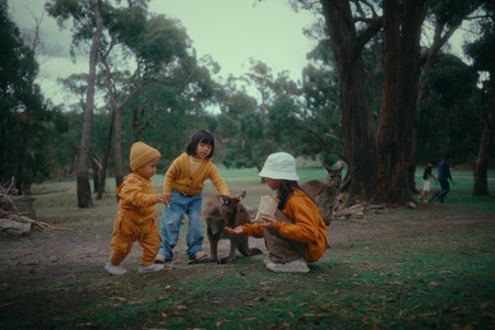 Children happily enjoying a delightful and playful moment with adorable animals in a beautiful outdoor settingの写真素材