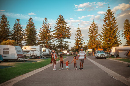 parents and kids walk happily, joyful family exploring scenic coastal caravan parkの写真素材