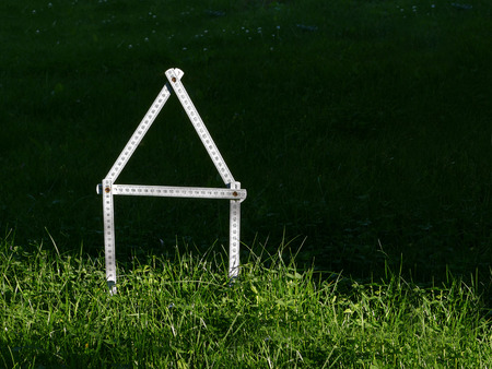 Dream of home ownership, house ruler icon on meadow / Building plotの写真素材