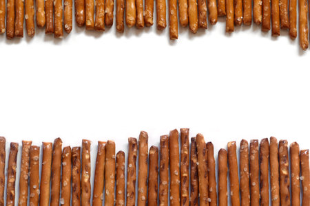 salted pretzel sticks in two rows on a white backgroundの写真素材