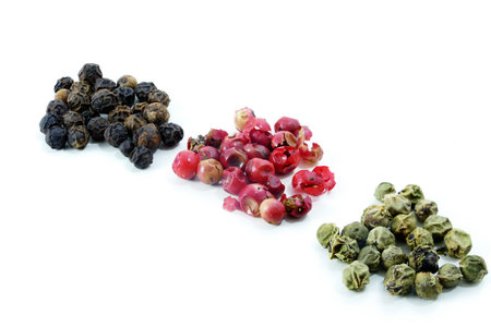 colored peppers on white background, black, green and red