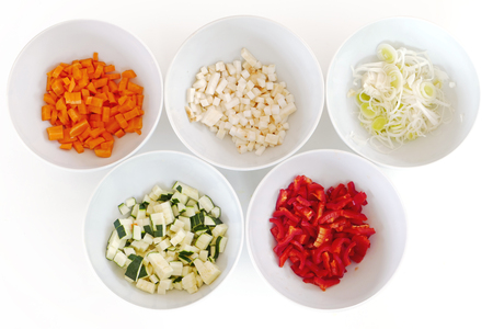 different kinds of chopped vegetables in white bowls, cooking preparationの写真素材