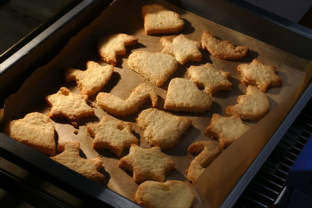 homemade cookies, stars and hearts on a baking tray fresh out of the oven