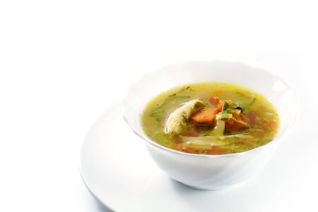 chicken soup with vegetables in a white bowl isolated on white backgroundの写真素材