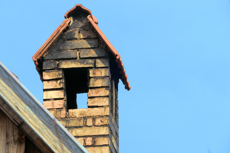 old chimney of brick with roof against blue sky, copy spaceの写真素材