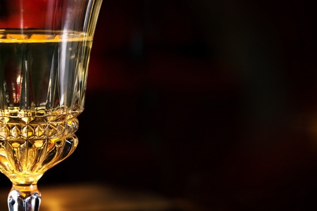 part of a wine glass at a romantic candle light dinner, blurred dark background with copy spaceの写真素材