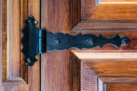 curved black hinge on an old wooden doorの写真素材