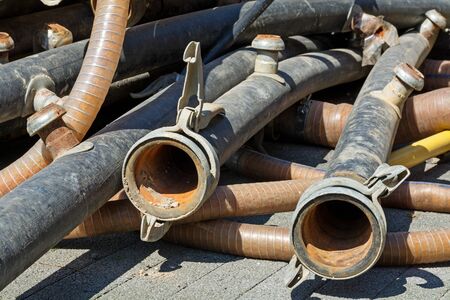 used rubber tubings with couplings on a construction siteの写真素材