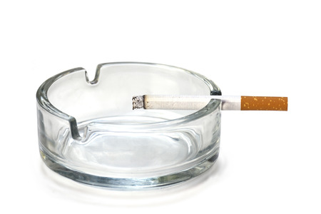 filter cigarette in an ashtray made of glass, isolated on a white backgroundの写真素材