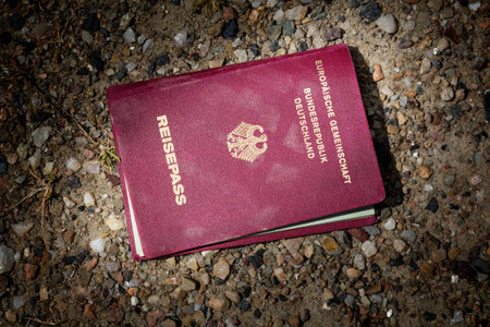lost passport of Germany lying on the dark sandy ground