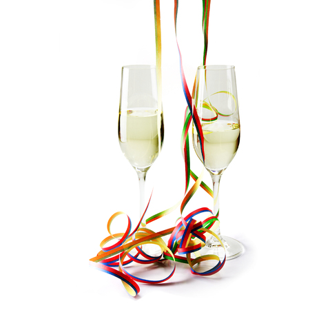 Two flute champagne glasses with colorful paper streamers isolated with shadows on a white background with shadowsの写真素材