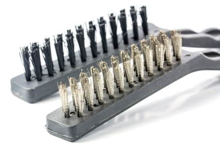two different wire brushes isolated with shadow on a white background, close up with selected focus...