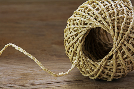Ball of string with texture and strands on a wooden background, close up shot, selected focusの写真素材