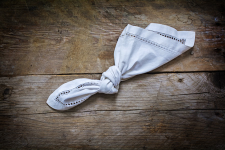reminder, knot in handkerchief of white cloth on a rustic wooden background with copy space, concept of recall and dementia, view from aboveの写真素材