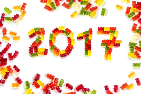 2017 made from colorful gummy bears and more gums around as a happy New Year greeting card, isolated with small shadows on a white backgroundの写真素材