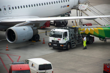 HAMBURG; GERMANY; JULY 27, 2016: Aircraft is refueled  by a tanker truck at the terminal in the international airport Hamburg FuhlsbÃ¼ttel in Germanyのeditorial素材