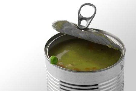 Fresh green pea on the edge of a tin can with vegetable soup, background fades to white, close up with selected focus and narrow depth of fieldの写真素材