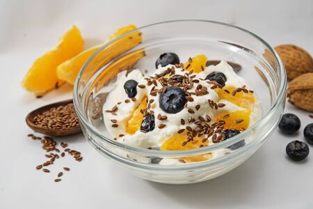 Quark, yogurt or cottage cheese, flax seeds and fresh fruits aug a light gray background, healthy diet for digestion, closeup with selected focus, narrow depth of fieldの写真素材