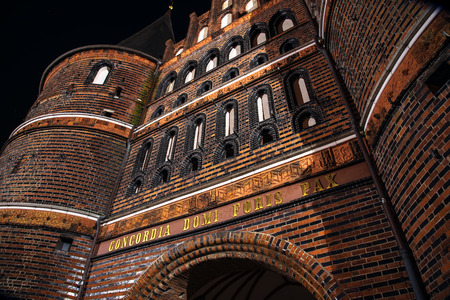 Holstentor in Luebeck at night, detail of the medieval city gate, a popular tourist attraction of the historic old town in Schleswig-Holstein, Germanyの写真素材