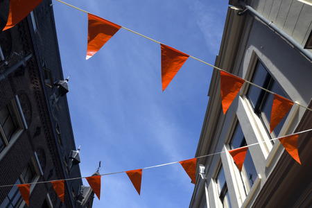 Orange flags in a Dutch city, decoration to support the soccer team or celebrate the queens day in the Netherlandsの写真素材