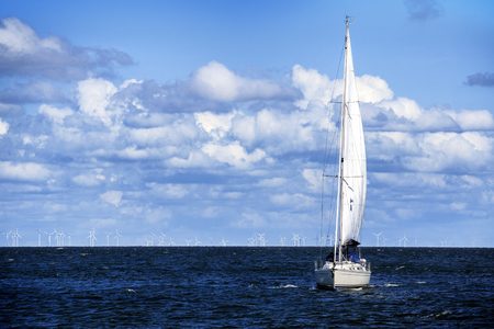 White sailing yacht on the blue sea against the sky with clouds, copy spaceの写真素材