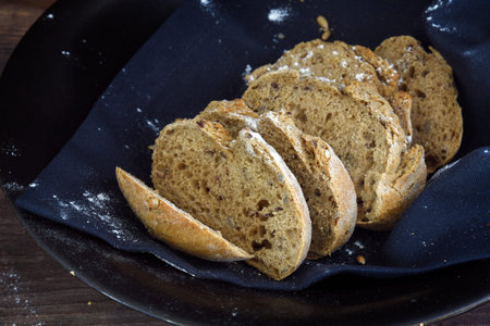 Crunchy wholemeal bread on a dark background, rustic homemade baking for al healthy lifestyle,...