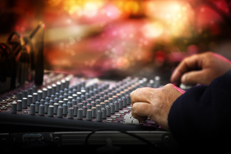 Working sound control panel or mixing console in front of the stage at a music festival concert, selected focus, narrow depth of field, blurry background bokehの写真素材