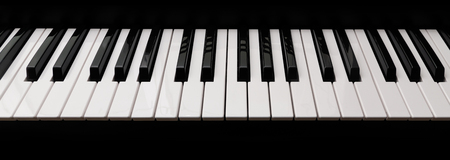grand piano keyboard with glossy black and white keys as a music background in wide panoramic banner format, selected focus, narrow depth of fieldの写真素材