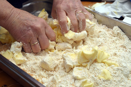 Older female hands are kneading a dough of butter and flour for baking a cake, copy space, selected...
