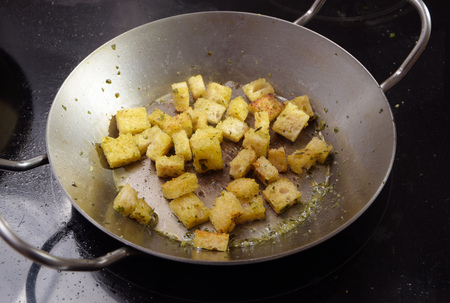 crispy croutons fried with herbs in a pan on the dark stove, cooking concept, selected focus, narrow depth of fieldの写真素材