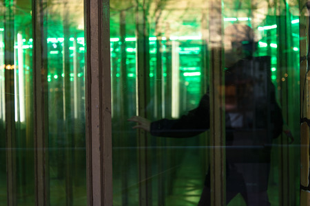 Unrecognizable person seeking the way out in a house of mirrorsの写真素材