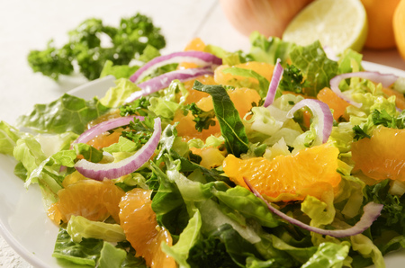 Healthy salad from tangerines and lettuce with red onions, close up shotの写真素材