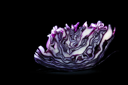 Slice of red cabbage with a beautiful texture isolated on a blackの写真素材
