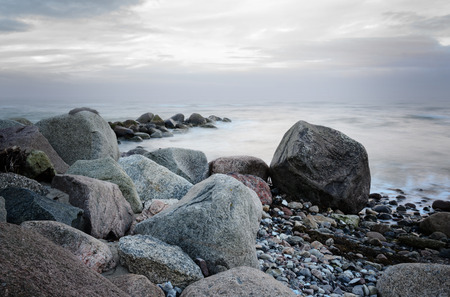 stones on the coast in the sea, soft waves by long time exposure, copy spaceの写真素材