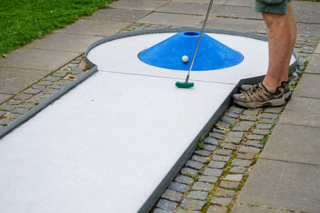 legs of a man at a mini golf course with a blue cone as an obstacle, copy space, selected focusの写真素材