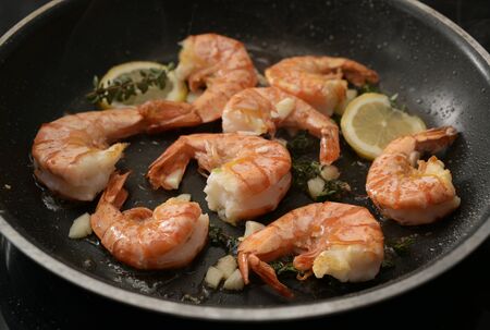roasted tiger prawn shrimps in a black pan with garlic, lemon and herbs, close up shot, selected focus, narrow depth of fieldの写真素材