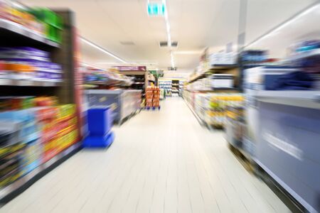 Abstract blurred supermarket aisle with modern shelves and goods for shopping, copy spaceの写真素材