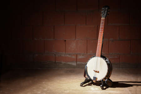 Banjo is standing in front of a raw brick wall in the rehearsal garage of a band, music concept, copy space, selected focusの写真素材