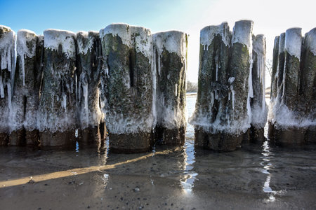 Iced groynes in early spring on the coast of the Baltic Sea in northern Germany, selected focus