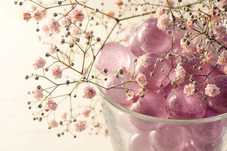 pink glass marbles and blush gypsophila flowers as a feminine decoration for beauty, wellness and romantic interior concepts, copy space, selected focus, narrow depth of fieldの写真素材