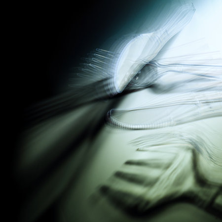 abstract image of transparent plastic cutlery, knives and forks with multiple exposure and motion blur, banned to protect the environment and the sea from microplastic, copy spaceの写真素材