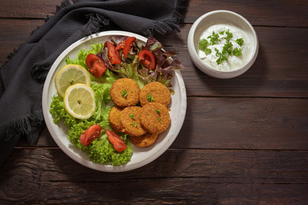 Fried falafel patties from chickpeas with sesame seeds, spices and herbs, lettuce salad with...