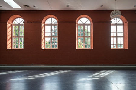 Putbus, Germany, August 22, 2021: red wall with arched windows in the empty hall of the Marstall in Putbus, Rugen, architecture and interior concept, copy space, selected focusのeditorial素材